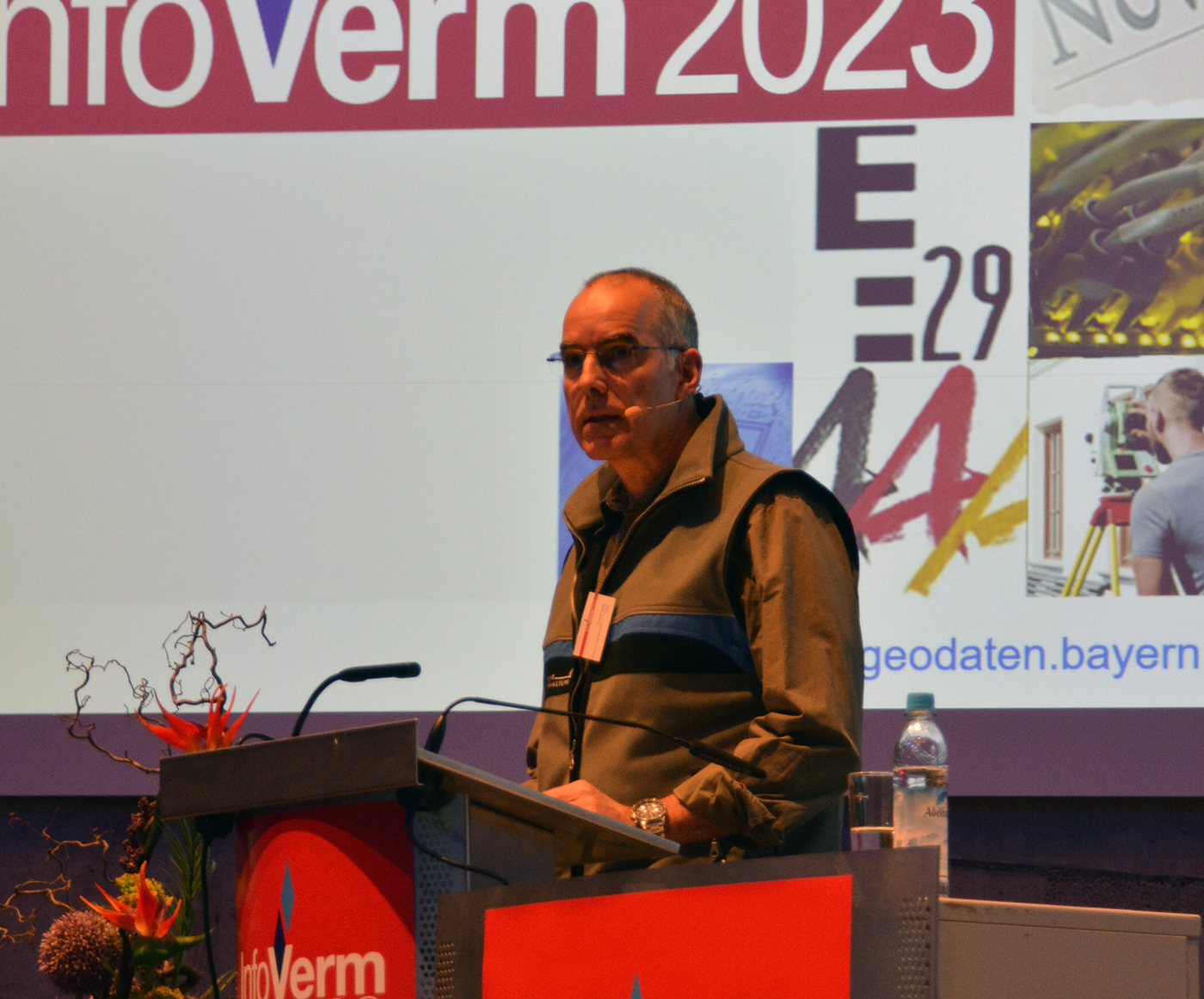 Ein Redner steht am Rednerpult und hält seinen Vortrag. Im Hintergrund steht zu lesen Verm 2023.